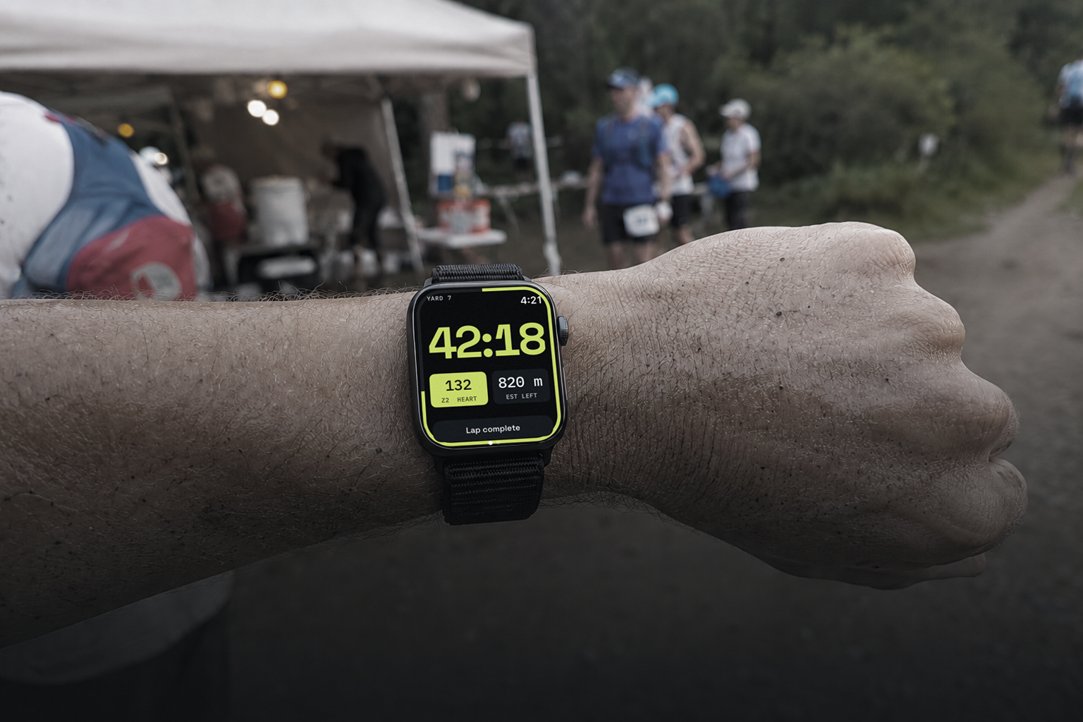 Runner glancing at Apple Watch during a Backyard Ultra lap